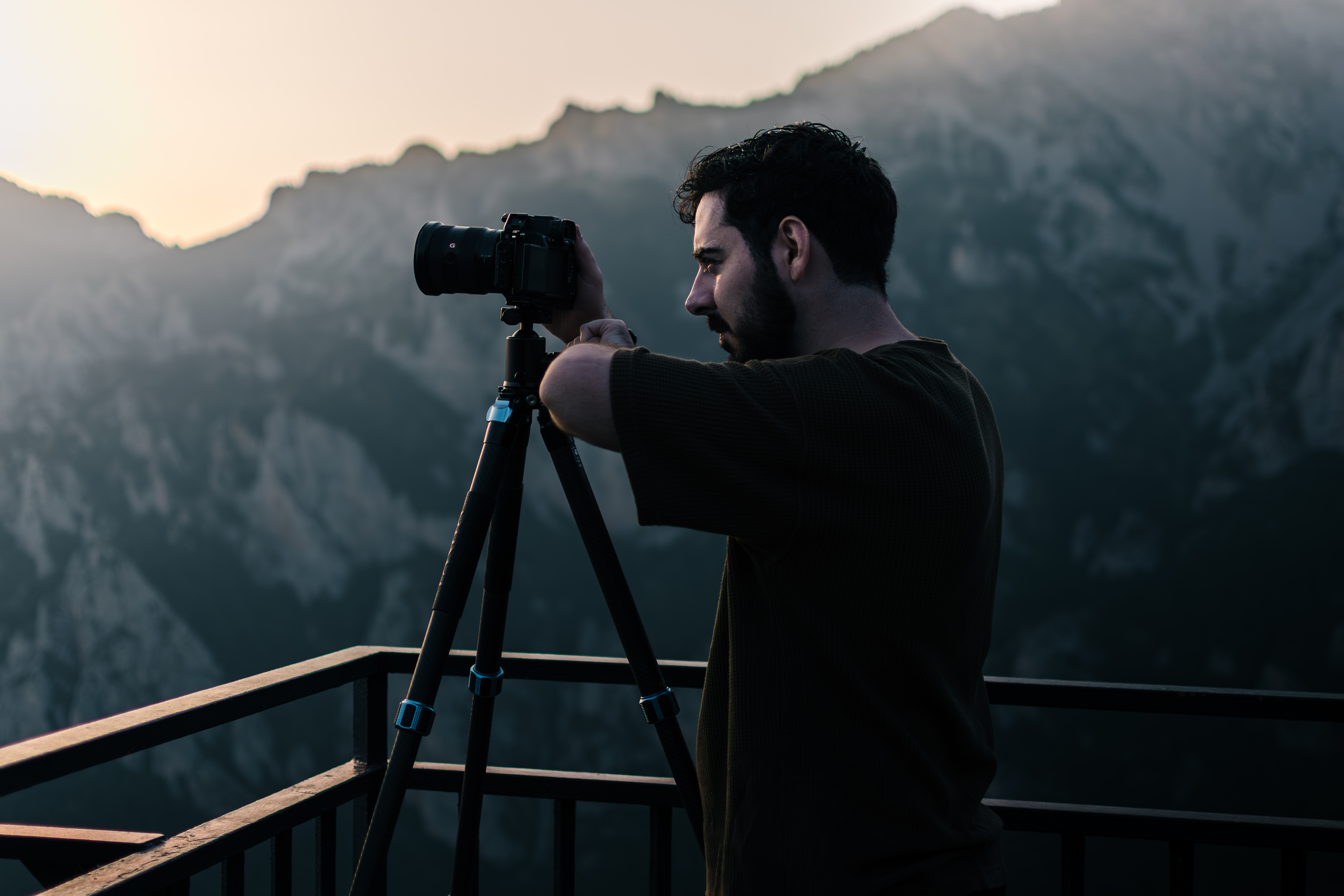 Gabriel con trípode al atardecer en la montaña